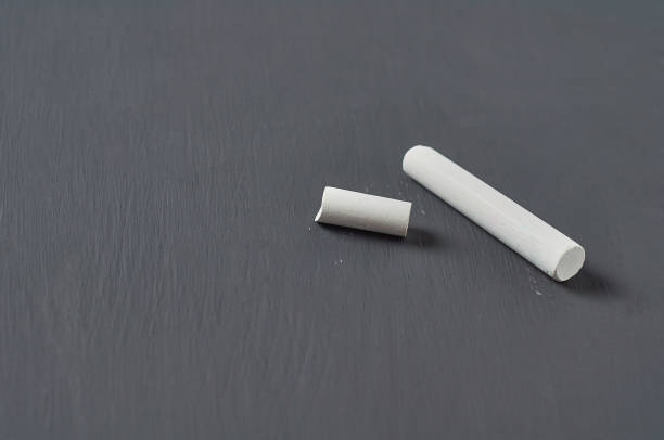 istock One white broken piece of chalk on black chalkboard. Copy space 1204871871