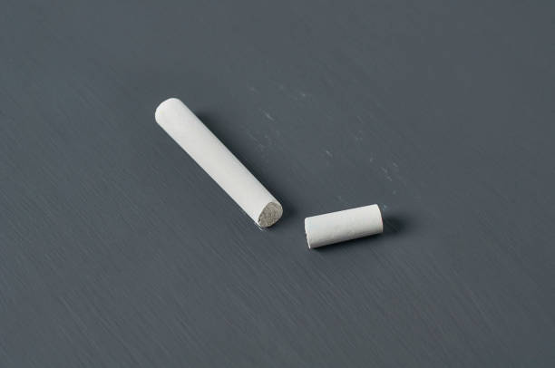 istock One white broken piece of chalk on black chalkboard. Close-up 1204871934