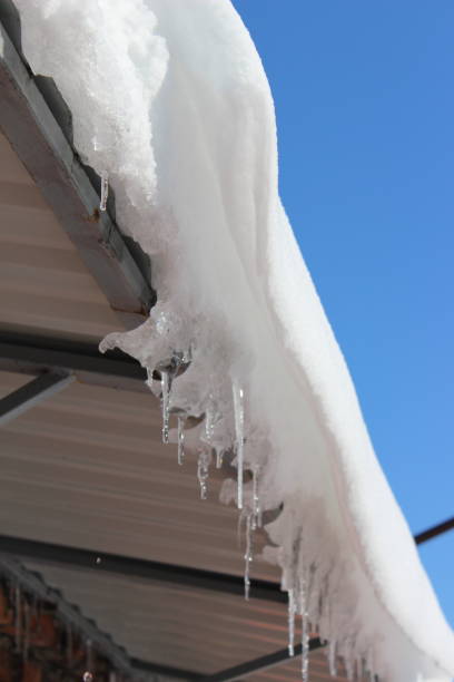 istock Spring roof with snow and icicles 1204872779