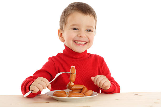 A girl is having a sausage for lunch