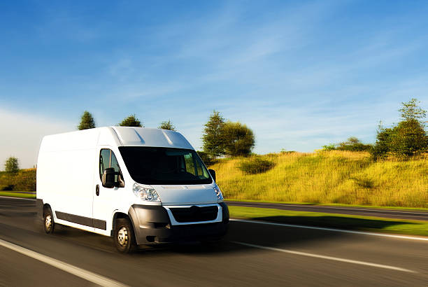 furgone di consegna bianco su strada - delivery van foto e immagini stock