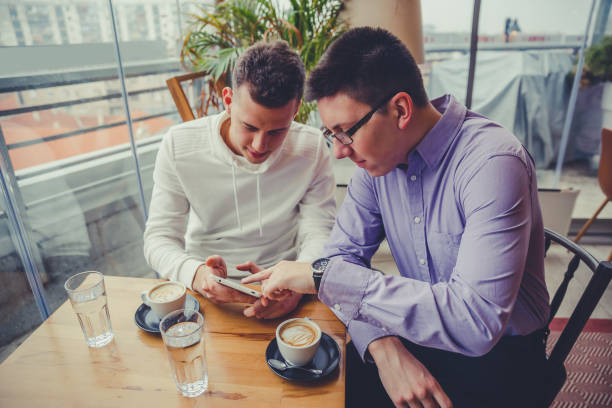 istock Male friends in cafe looking at tablet 1204889210
