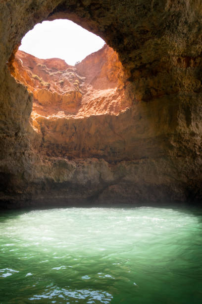 istock Cave in the water with natural hole in the ceiling through which natural light falling down to the water in Algarve region in Portugal 1204894727