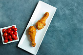 KFC chiken fried legacies with tomatos on the white plates