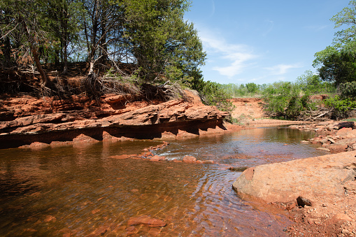 The river flow along red stones in park
