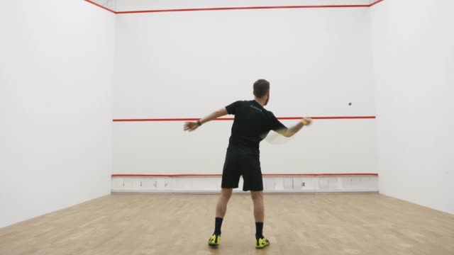 A portrait of a young bearded man practicing to play squash