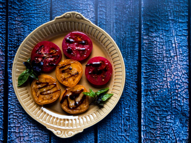 pomodori rossi e arancioni affettati con olio d'oliva, basilico, aceto balsamico - vinegar salad dressing balsamic vinegar olive oil foto e immagini stock