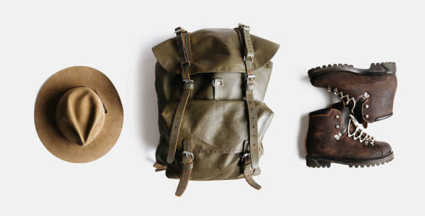 istock Minimalist style composition of hat, backpack and boots on white background isolated 1204906982