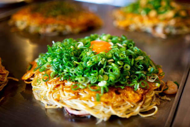 okonomiyaki hiroshima con farina d'uovo giappone - okonomiyaki foto e immagini stock