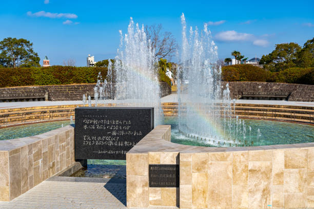 fuente de la paz en el parque de la paz de nagasaki en un día soleado. prefectura de nagasaki, japón - war globe symbols of peace weapon fotografías e imágenes de stock