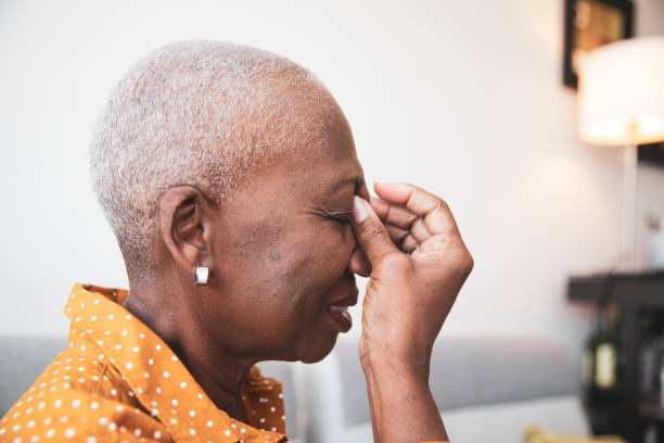 Senior Woman With a Headache senior African descent woman holding her head in pain shaved black women stock pictures, royalty-free photos & images