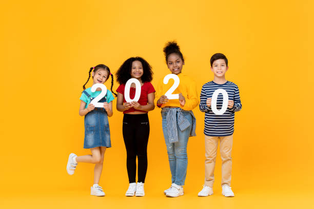 istock Cute mixed race kids smiling and holding 2020 numbers 1204923528