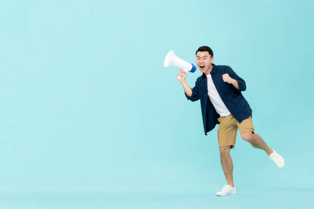istock Excited young Asian man holding megaphone and shouting 1204923549