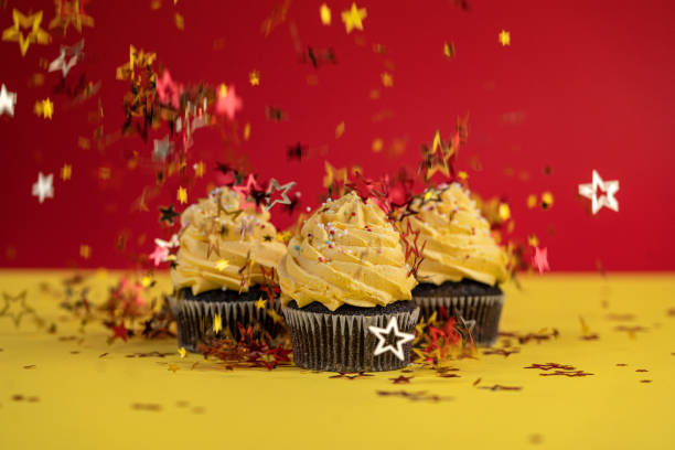 köstliche cupcakes mit konfetti in form von stern bestreut - back to front ideas surrealism concepts stock-fotos und bilder
