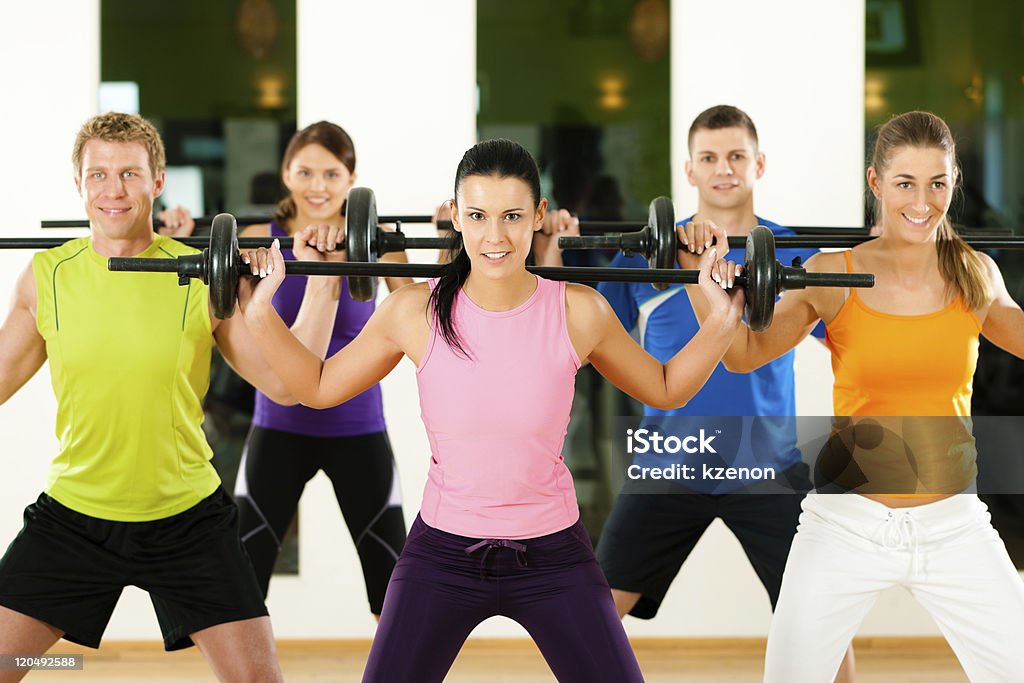 Grupo de gimnasia con barra para pesas en el gimnasio - Foto de stock de Adulto libre de derechos