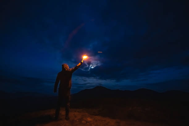 istock The male with a firework stick standing on a mountain. evening night time 1204927736