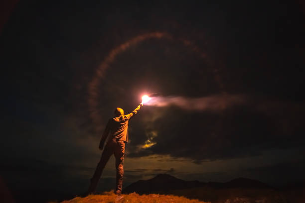 istock The man with a bright firework stick standing on a mountain. evening night time 1204927737