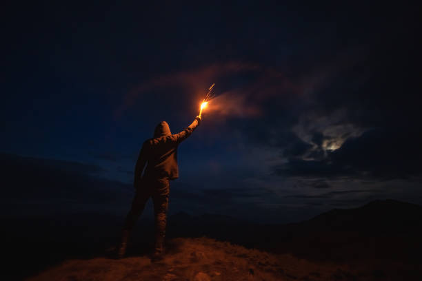 istock The male with a firework stick standing on the night mountain 1204927753