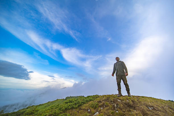 istock The male standing on the mountain on a cloudy sky background 1204927754