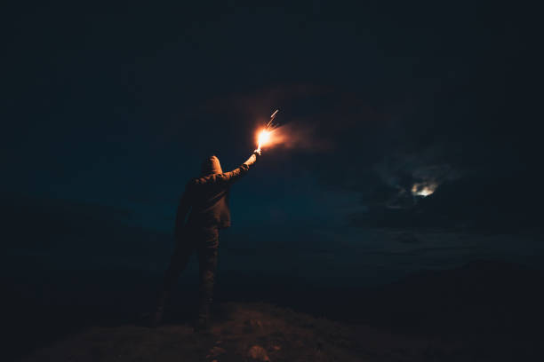 istock The male with a firework stick standing on the night mountain 1204927799