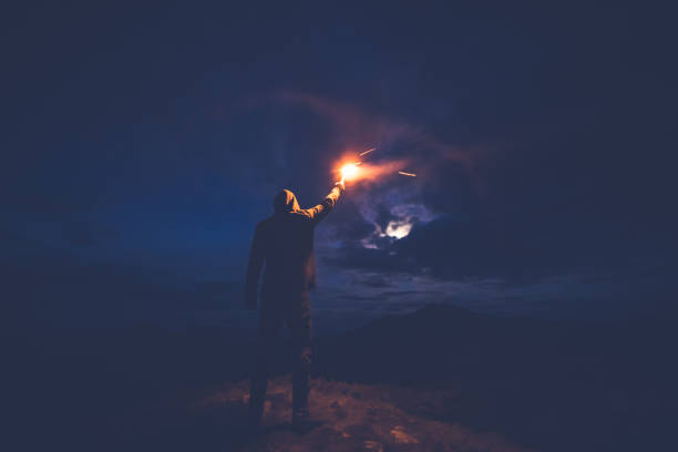 istock The man with a firework stick standing on the night mountains 1204927814