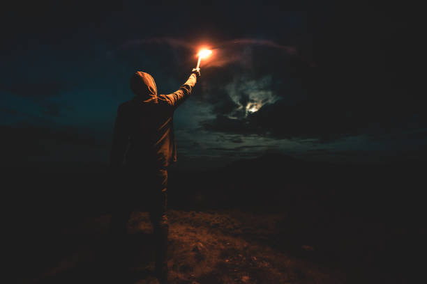 istock The male with a bright firework stick standing on the night mountain 1204927820
