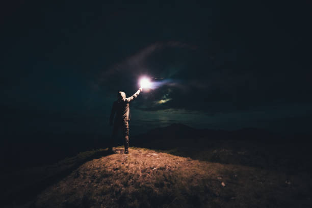 istock The male with a bright firework stick standing on the night mountain 1204927838