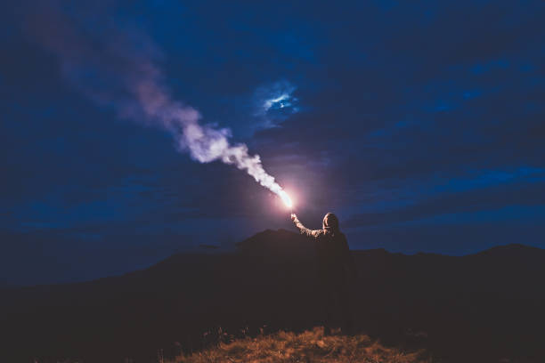 istock The male standing with a firework stick on the night mountain 1204927841