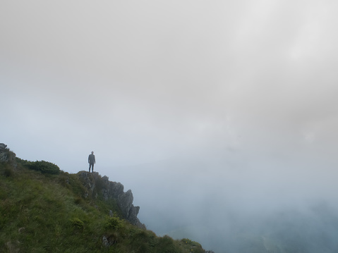 The man standing on the foggy rock