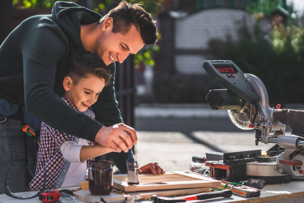 istock The father and son coat with paint some carpentry 1204931102