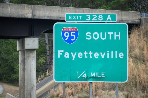 A highway sign leads the way to Fayetteville, NC, and Fort Bragg, via Interstate 95.