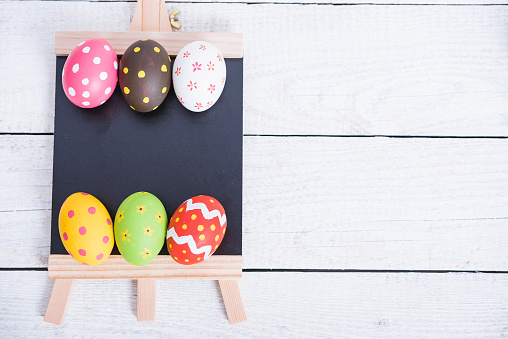 Easter eggs top view on white wooden background and have board work space board for use