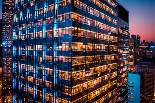 Office building at night with illuminated windows.