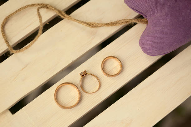 istock Three wedding rings on wooden background 1204956498