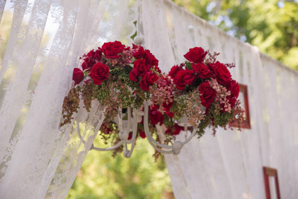 Chandelier decorated with fresh dark red roses Outdoor front yard decoration with white chandelier decorated with maroon roses and fresh gypsophila plants chandelier earring stock pictures, royalty-free photos & images