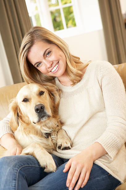 istock Young woman with dog sitting on sofa 120495748