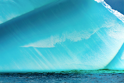 Floating Blue Iceberg Floating Sea Water Charlotte Bay Antarctic Peninsula Antarctica.  Glacier ice blue because air squeezed out of snow.