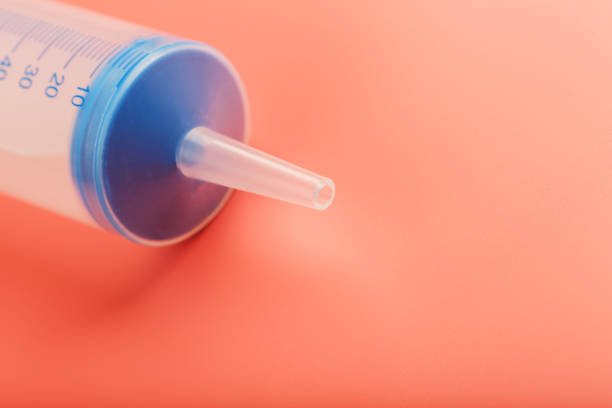 istock Large medical syringe on pink background with scale, copy space. 1204969484