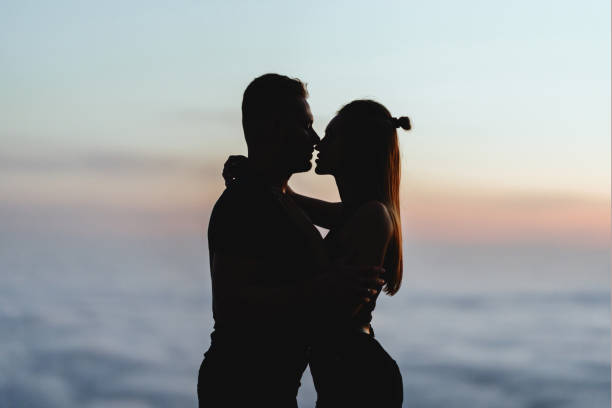 istock Happy couple watching one another under the sunset sky 1204971420