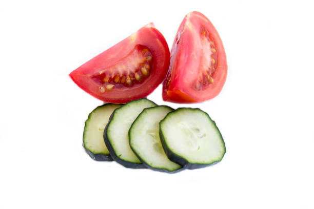 istock Cut tomato and cucumber isolated on white 1204976758