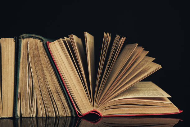 istock Beautiful ancient books. Pattern background for design. The book on a black glass table  background. 1204977859