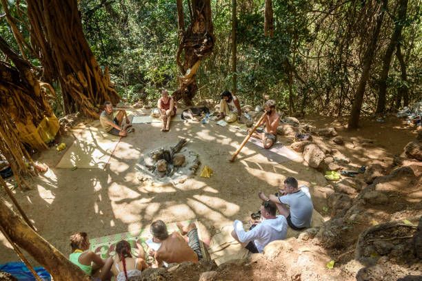 People under big banyan tree in Arambol. Goa Arambol, India - March 02, 2019: People under big banyan tree in Arambol.  In this place always find  friendly group of beach pilgrims and holy men didgeridoo stock pictures, royalty-free photos & images