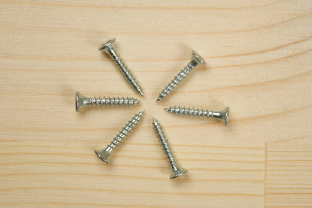 istock Screws on wooden surface 1204979530