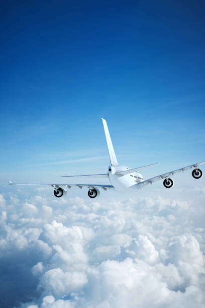 istock White passenger aircraft flying over clouds 1204984245