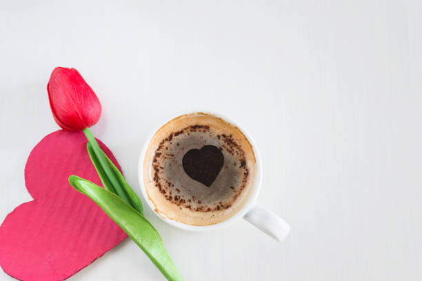 istock Romantic composition with cup of coffee and red tulip 1204987439