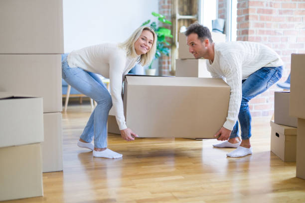 istock Young beautiful couple moving cardboard boxes at new home 1204994467