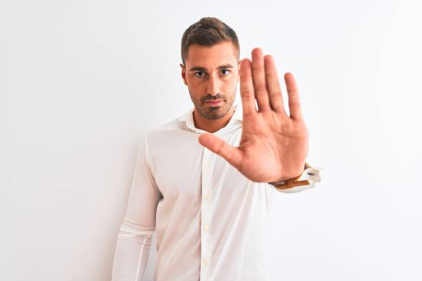 istock Young handsome business man wearing elegant shirt over isolated background doing stop sing with palm of the hand. Warning expression with negative and serious gesture on the face. 1204994799