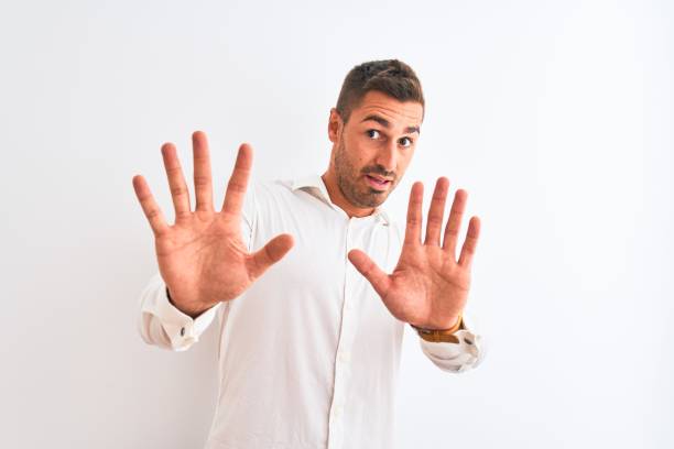 istock Young handsome business man wearing elegant shirt over isolated background afraid and terrified with fear expression stop gesture with hands, shouting in shock. Panic concept. 1204994809