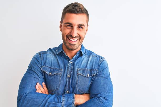 istock Young handsome man wearing denim jacket standing over isolated background happy face smiling with crossed arms looking at the camera. Positive person. 1204996466