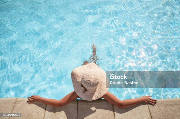 Young Woman Relaxing In The Swimming Pool Stock Photo - Download Image Now - Swimming Pool, Women, Relaxation
